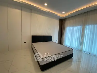 Spacious bedroom with modern design and large windows for natural light.