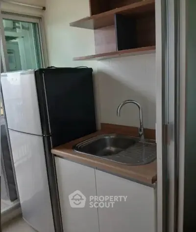Compact kitchen with fridge and sink, ideal for small apartments