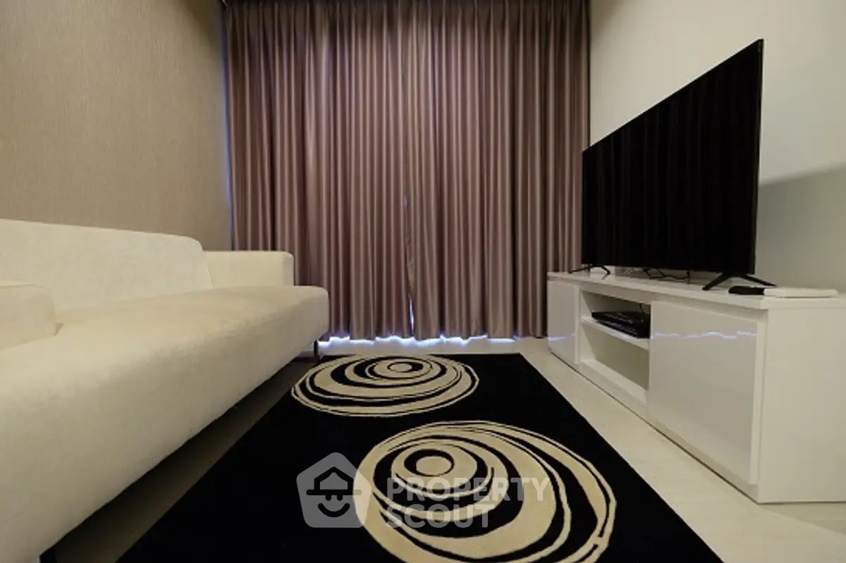 Modern living room with stylish decor and large flat-screen TV