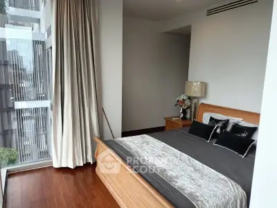 Luxurious bedroom with floor-to-ceiling windows and elegant decor in modern apartment.