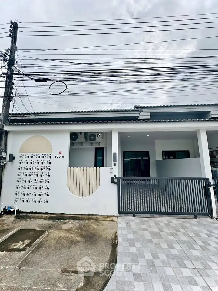 Modern townhouse exterior with gated entrance and unique wall design, perfect for urban living.
