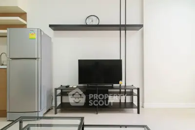 Modern living room with sleek TV stand and stainless steel fridge, perfect for contemporary urban living.