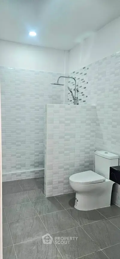 Modern bathroom with sleek tiles and contemporary fixtures in a real estate property.