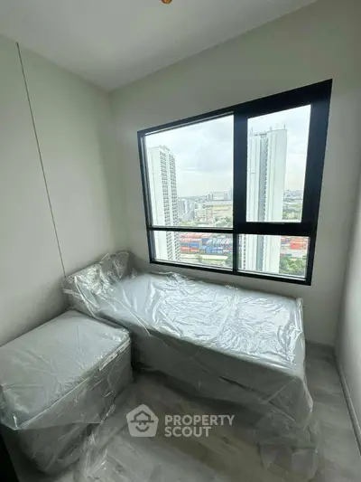 Compact bedroom with city view, featuring a single bed and modern window design.