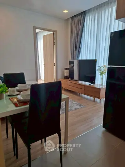 Modern living room with dining area, sleek furniture, and natural light.