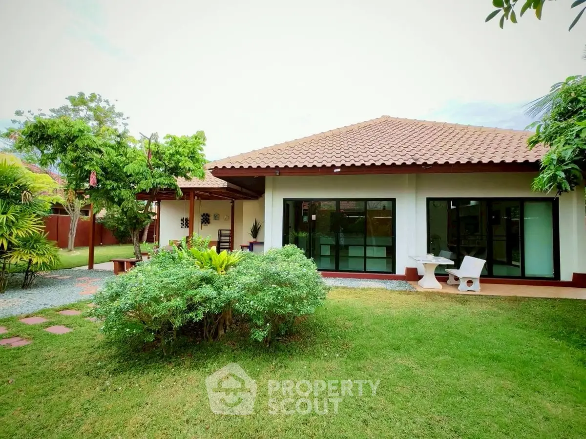 Charming single-story home with lush garden and patio seating.