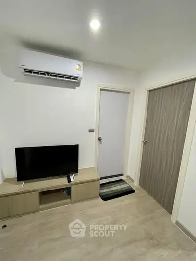 Modern living room with air conditioning and sleek TV setup in a stylish apartment.