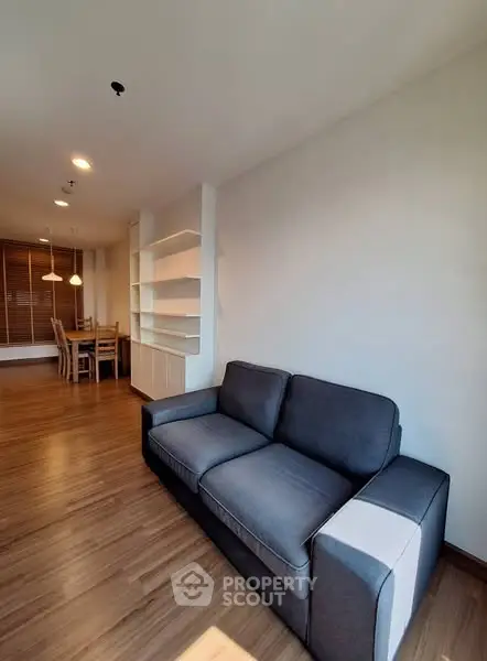 Spacious living room with modern sofa and dining area, perfect for relaxation and entertainment.