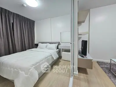 Modern bedroom with cozy bed, stylish decor, and sleek TV setup in a contemporary apartment.