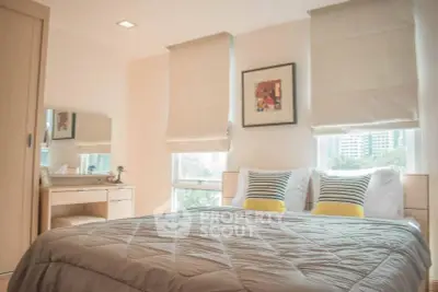 Cozy bedroom with modern decor and large windows offering city views.