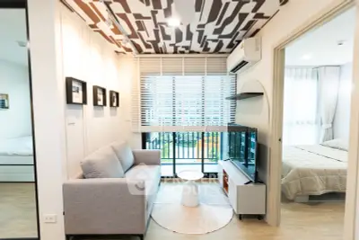 Modern living room with stylish ceiling design and balcony view in a cozy apartment.