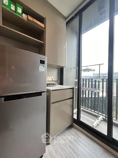 Modern kitchen with sleek appliances and balcony view in urban apartment