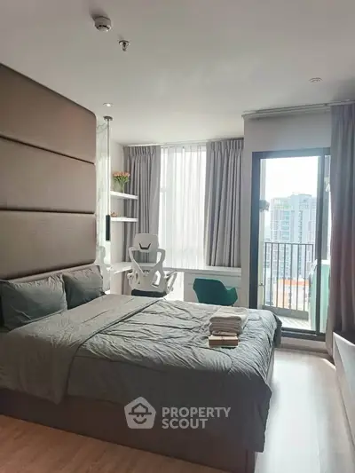 Modern bedroom with balcony and city view, featuring stylish decor and natural light.