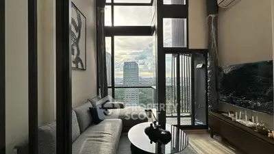 Luxurious high-rise living room with floor-to-ceiling windows and stunning city view.