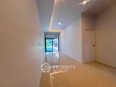 Spacious modern hallway with glossy tiled floors and recessed lighting