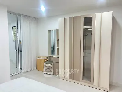 Modern bedroom with sleek wardrobe and vanity in a bright, minimalist design.