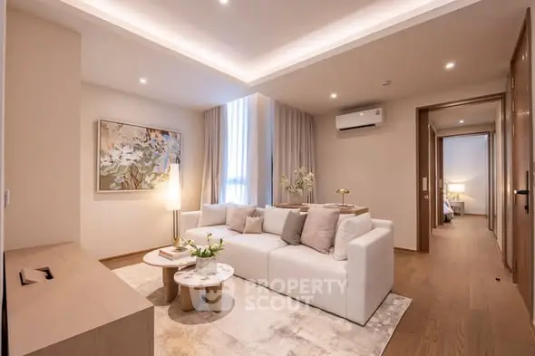 Elegant living room with modern decor and cozy ambiance, featuring a plush white sofa and stylish artwork.