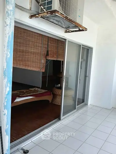 Spacious balcony with sliding glass doors and tiled flooring