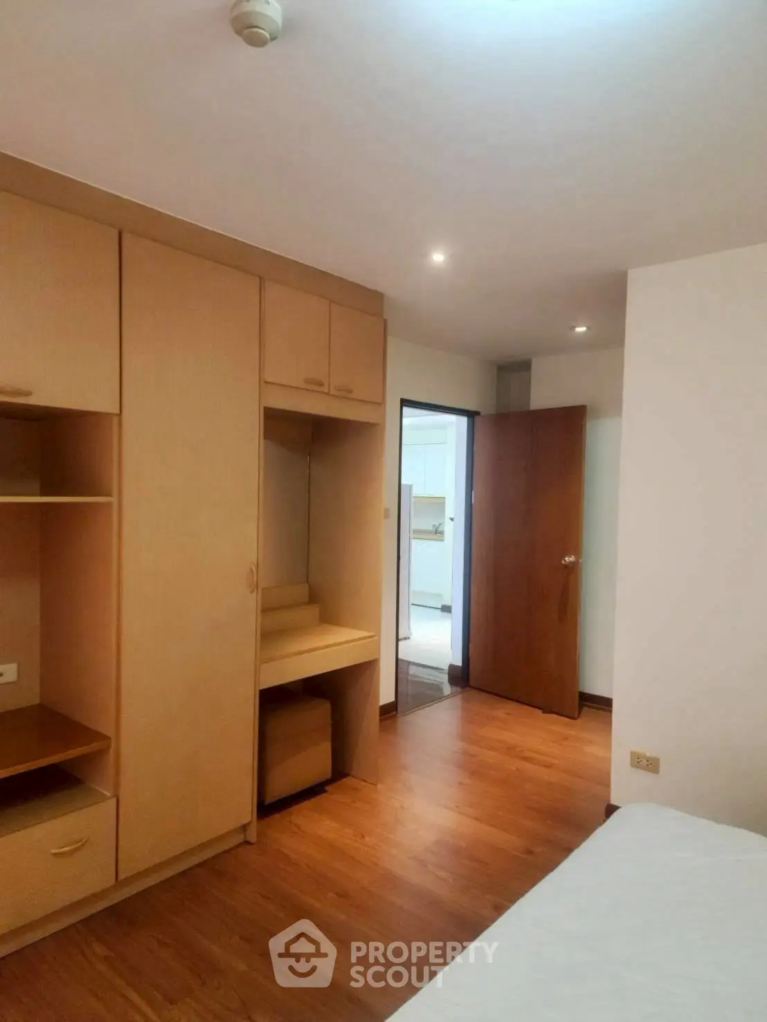 Spacious bedroom with built-in wooden wardrobe and cozy ambiance