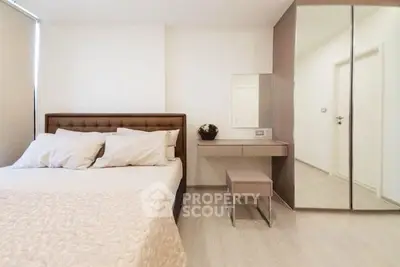 Modern bedroom with stylish decor and mirrored wardrobe in a cozy apartment.