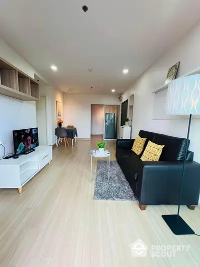 Modern living room with sleek furniture and wooden flooring in a stylish apartment.