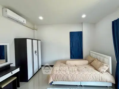 Spacious bedroom with modern furnishings and natural light, featuring a comfortable bed and sleek wardrobe.