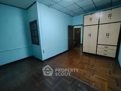 Spacious empty room with parquet flooring and built-in wardrobe, ideal for customization.