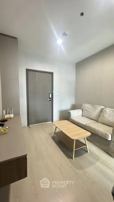 Modern living room with beige sofa and wooden coffee table in a cozy apartment.