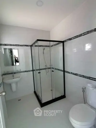Modern bathroom with glass shower enclosure and sleek white fixtures