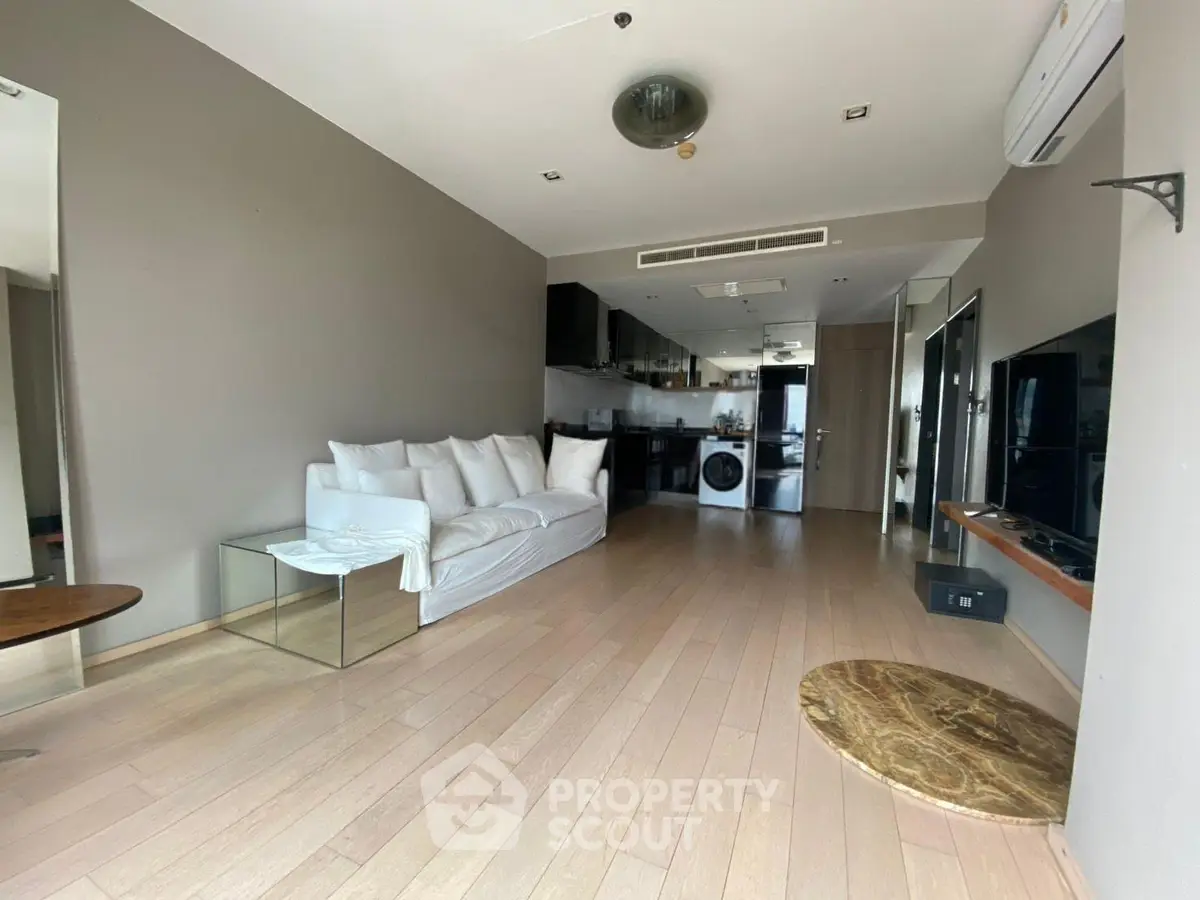 Spacious modern living room with open kitchen and sleek design in a contemporary apartment.
