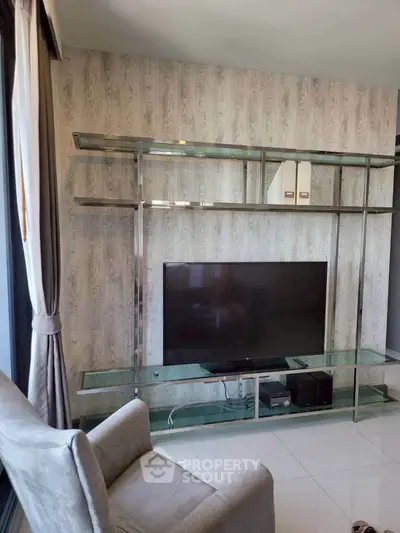 Modern living room with sleek TV stand and comfortable armchair, perfect for relaxation.