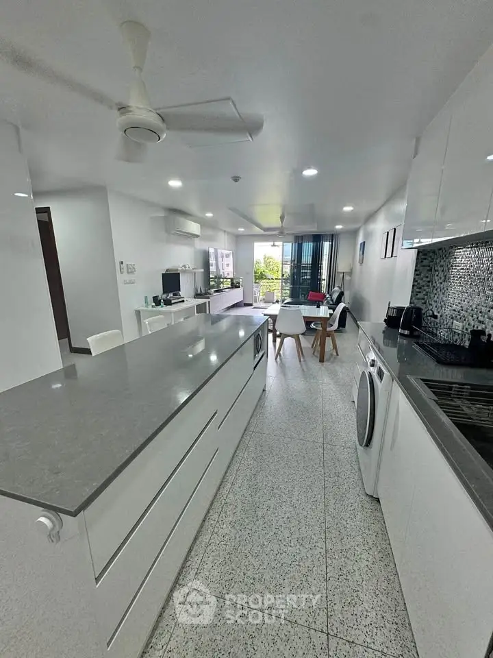 Modern open-plan kitchen with sleek design and spacious living area, perfect for contemporary living.