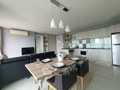 Modern open-plan living room and kitchen with stylish dining area and sleek appliances.