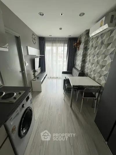 Modern living room with washing machine, stylish decor, and natural light.