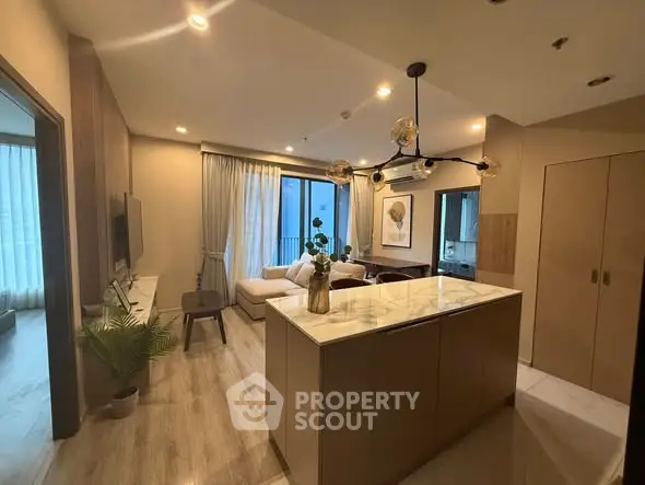 Modern open-layout living room with stylish decor and large windows for natural light.