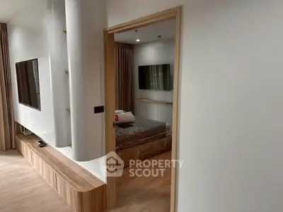 Modern apartment interior with sleek TV unit and cozy bedroom view