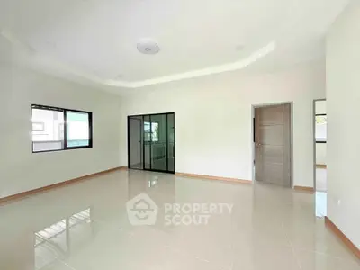 Spacious empty room with large windows and modern sliding doors, perfect for customization.