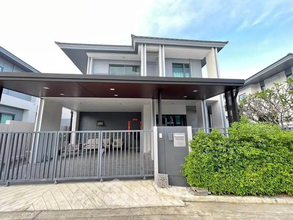 Modern two-story house with sleek design and spacious driveway in a serene neighborhood.