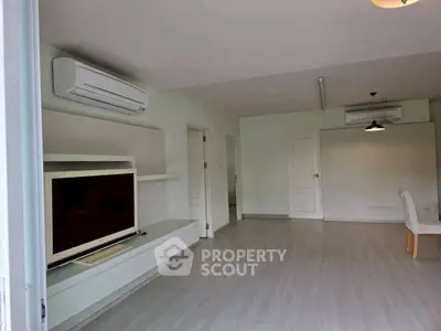 Spacious living room with modern air conditioning and sleek flooring, perfect for comfortable living.