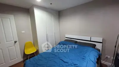 Cozy bedroom with modern wardrobe and vibrant yellow chair