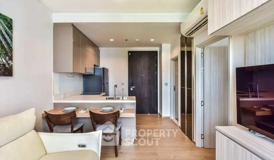 Modern open-layout kitchen and living area with sleek design and wooden flooring.
