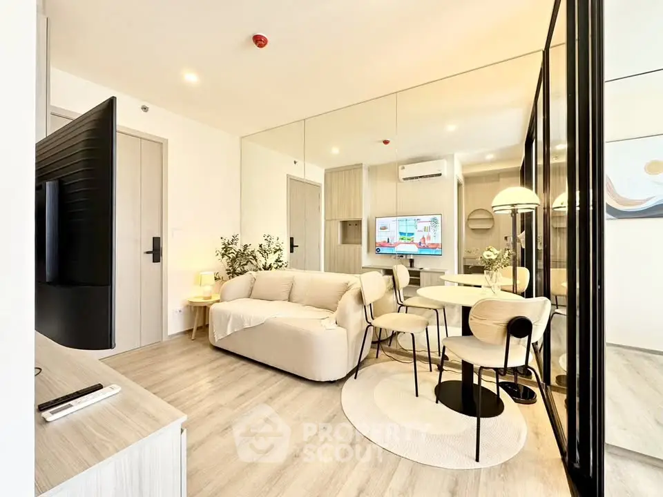 Modern living room with stylish decor and open layout, featuring a cozy sofa and sleek dining area.