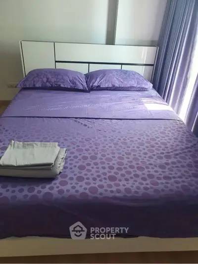 Cozy bedroom with purple bedding and natural light