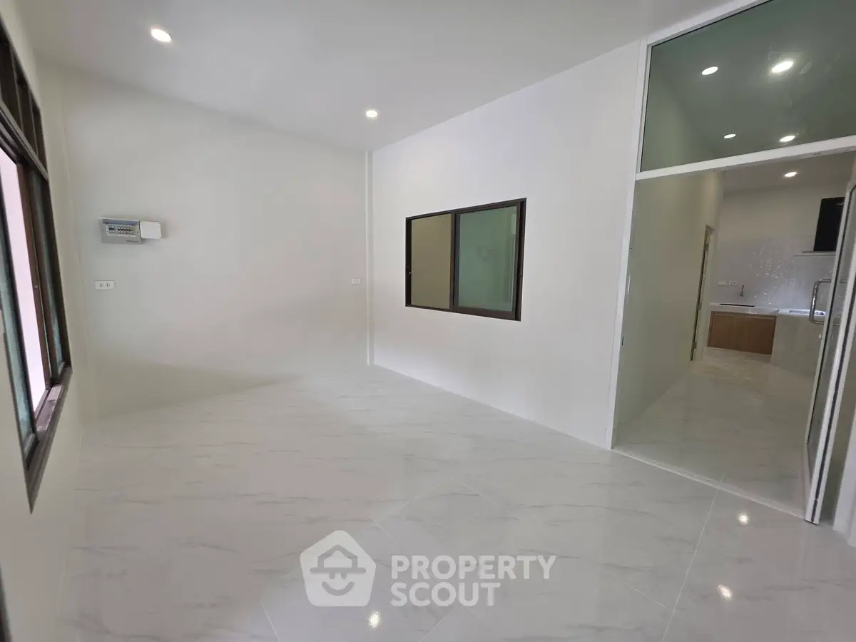 Spacious modern living room with sleek tile flooring and large windows for natural light.