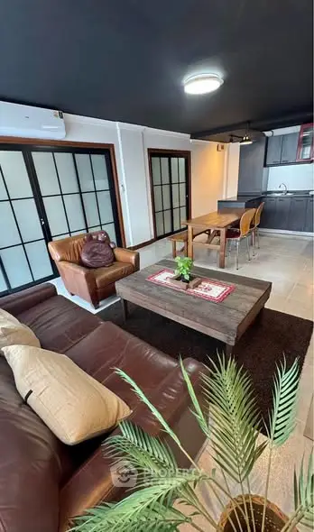 Stylish open-plan living room with modern kitchen and cozy seating area.