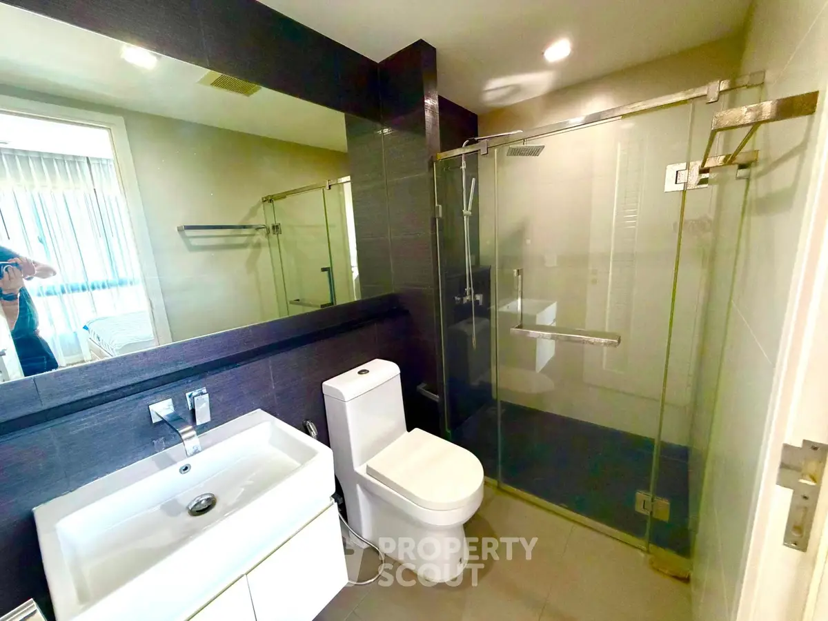 Modern bathroom with glass shower and sleek fixtures in a contemporary home.