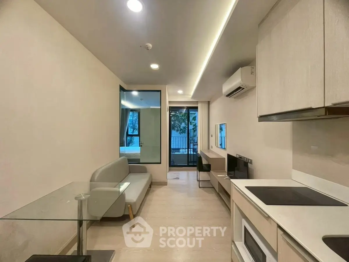 Modern open-plan living room with sleek kitchen and cozy seating area.