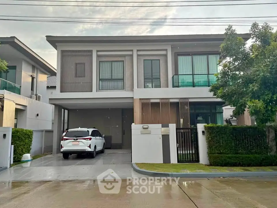 Modern two-story house with sleek design and spacious driveway in a serene neighborhood.