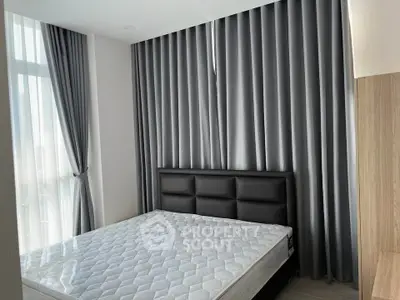 Modern bedroom with sleek design, featuring a comfortable bed and elegant floor-to-ceiling curtains.