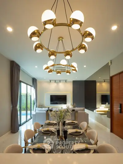 Luxurious open-plan living and dining area with elegant chandelier and modern decor.